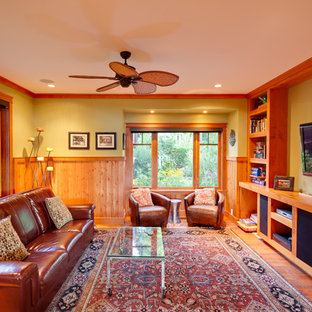 Klassisches Wohnzimmer mit grüner Wandfarbe, braunem Holzboden, Wand-TV und orangem Boden in Vancouver