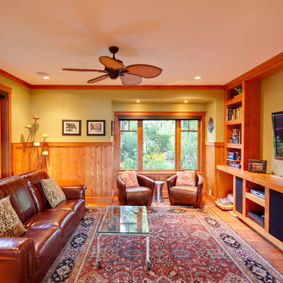 Elegant medium tone wood floor and orange floor family room photo in Vancouver with green walls and a wall-mounted tv
