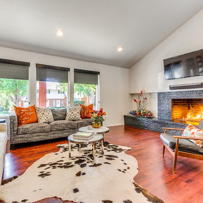 Large eclectic medium tone wood floor family room photo in Oklahoma City with a standard fireplace, a brick fireplace and a wall-mounted tv