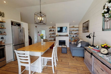 Small mountain style open concept laminate floor and brown floor family room photo in Boston with white walls, a standard fireplace and a wood fireplace surround