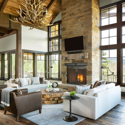 Example of a mountain style open concept medium tone wood floor family room design in Denver with white walls, a standard fireplace, a stone fireplace and a wall-mounted tv
