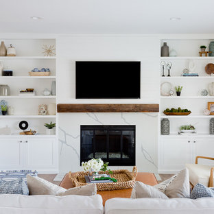 Abgetrenntes Maritimes Wohnzimmer mit weißer Wandfarbe, braunem Holzboden, Kamin, Wand-TV und braunem Boden in Orange County