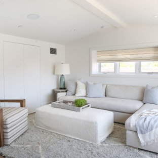 Beach style medium tone wood floor and brown floor family room photo in Orange County with white walls