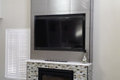Photo of a modern games room in Other with a standard fireplace, a tiled fireplace surround and a wall mounted tv.