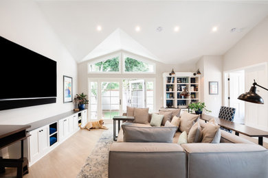 Klassisches Wohnzimmer mit grauer Wandfarbe, hellem Holzboden, TV-Wand, beigem Boden und gewölbter Decke in Los Angeles