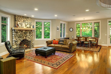 Diseño de sala de estar abierta de estilo de casa de campo grande con suelo de madera en tonos medios, todas las chimeneas y marco de chimenea de piedra