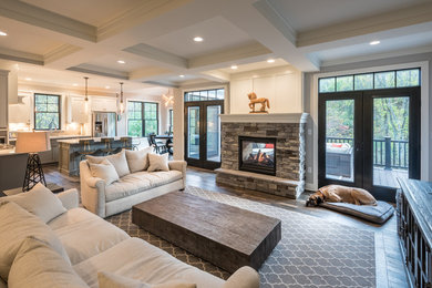 Inspiration for a cottage open concept dark wood floor and brown floor family room remodel in Other with gray walls, a two-sided fireplace, a stone fireplace and a tv stand