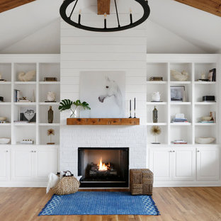 Mittelgroßes, Offenes Landhausstil Wohnzimmer mit weißer Wandfarbe, hellem Holzboden, Kamin, Kaminumrandung aus Backstein, Wand-TV und buntem Boden in Nashville