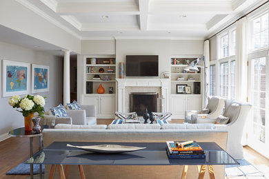 Large eclectic open concept medium tone wood floor and brown floor family room photo in Chicago with gray walls, a standard fireplace, a tile fireplace and a wall-mounted tv