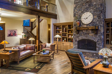 Family room - large rustic enclosed dark wood floor and brown floor family room idea in Other with white walls, a standard fireplace, a stone fireplace and no tv