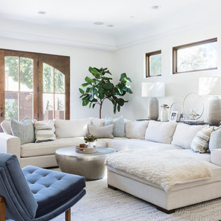 Großes Mediterranes Wohnzimmer mit weißer Wandfarbe, braunem Holzboden und braunem Boden in Los Angeles