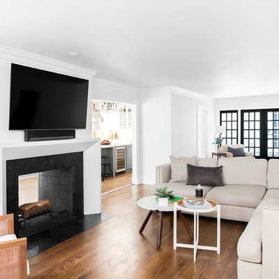 Family room - mid-sized transitional enclosed medium tone wood floor and brown floor family room idea in Dallas with white walls, a two-sided fireplace, a tile fireplace and a wall-mounted tv
