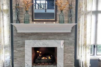 シカゴにある高級な中くらいなトランジショナルスタイルのおしゃれなオープンリビング (青い壁、カーペット敷き、横長型暖炉、石材の暖炉まわり、テレビなし、グレーの床) の写真