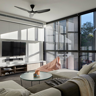 Inspiration for a contemporary family room in Melbourne with white walls, carpet, a wall-mounted tv and grey floor.