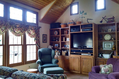 Ejemplo de sala de estar cerrada tradicional renovada pequeña sin chimenea con paredes beige, moqueta, pared multimedia y suelo naranja