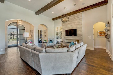 Mediterranean games room in Dallas with medium hardwood flooring, a tiled fireplace surround and a wall mounted tv.