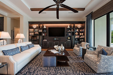 Example of a large transitional medium tone wood floor family room design in Miami with a media wall