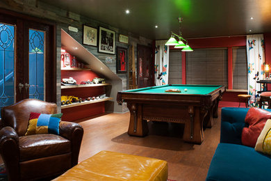 Ejemplo de sala de juegos en casa cerrada ecléctica pequeña sin chimenea con paredes rojas, suelo de corcho y televisor colgado en la pared