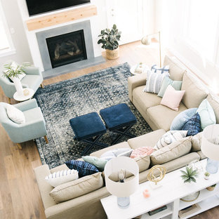 Großes, Offenes Klassisches Wohnzimmer mit grauer Wandfarbe, braunem Holzboden, Kamin, Kaminumrandung aus Beton und Wand-TV in Salt Lake City