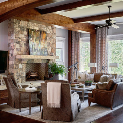 Inspiration for a rustic open concept medium tone wood floor family room remodel in Raleigh with gray walls, a standard fireplace, a stone fireplace and a wall-mounted tv