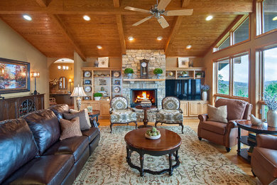 Imagen de sala de estar abierta tradicional renovada grande con paredes beige, suelo de madera clara, todas las chimeneas, marco de chimenea de piedra y pared multimedia