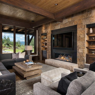 Example of a large mountain style open concept medium tone wood floor and brown floor family room design in Denver with a bar, beige walls, a metal fireplace, a wall-mounted tv and a ribbon fireplace