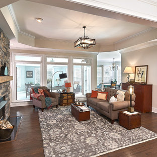 Inspiration for a mid-sized country open concept dark wood floor and brown floor family room remodel in Charlotte with beige walls, a standard fireplace, a stone fireplace and no tv