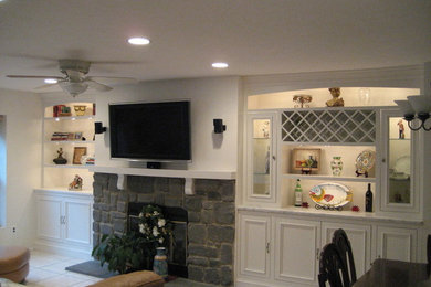 Example of a mid-sized classic family room design in Philadelphia with white walls, a standard fireplace, a stone fireplace and a wall-mounted tv