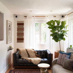 Example of a small eclectic medium tone wood floor family room design in Cleveland with white walls