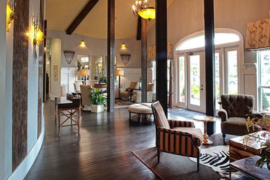 Cette image montre une grande salle de séjour traditionnelle ouverte avec un mur gris et parquet foncé.