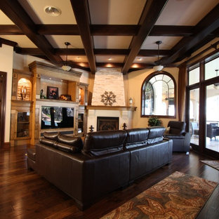 Family room - large mediterranean open concept dark wood floor family room idea in Tampa with beige walls, a corner fireplace, a stone fireplace and a media wall