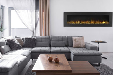 Diseño de sala de estar abierta clásica renovada grande con chimeneas suspendidas, paredes blancas, suelo de madera clara y marco de chimenea de yeso