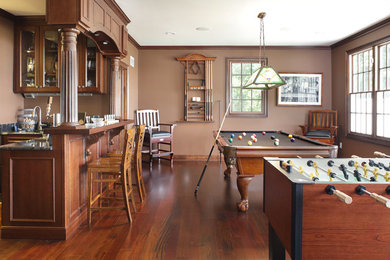 Ejemplo de sala de juegos en casa tradicional renovada grande sin chimenea y televisor con paredes marrones y suelo de madera en tonos medios