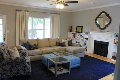 Imagen de sala de estar abierta clásica renovada de tamaño medio con paredes grises, suelo de madera clara y pared multimedia