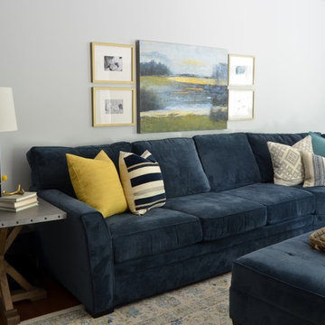 Navy sectional with yellow, gray and blue patterned pillows
