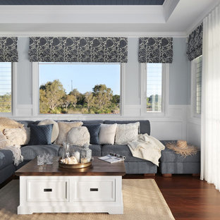 Inspiration for a large beach style open concept family room in Sunshine Coast with multi-coloured walls, dark hardwood floors, a wall-mounted tv, brown floor, coffered and decorative wall panelling.