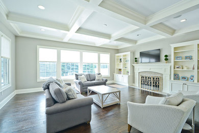 Example of a large transitional open concept dark wood floor family room design in Indianapolis with gray walls, a standard fireplace, a wood fireplace surround and a wall-mounted tv