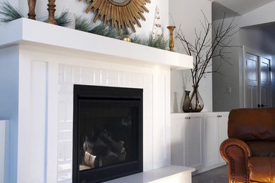 バンクーバーにある低価格のトランジショナルスタイルのおしゃれなファミリールーム (白い壁、カーペット敷き、標準型暖炉、タイルの暖炉まわり) の写真