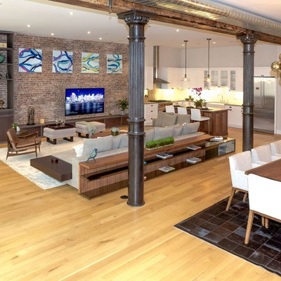 Example of a huge trendy loft-style light wood floor and beige floor family room design in New York with white walls, no fireplace and a media wall