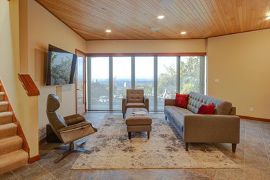 Foto de sala de estar actual sin chimenea con paredes beige, suelo de pizarra, televisor colgado en la pared y suelo multicolor
