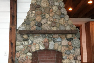 Family room - rustic family room idea in Manchester with a corner fireplace and a stone fireplace