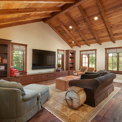 Family room - large rustic open concept dark wood floor family room idea in Santa Barbara with beige walls, no fireplace and a wall-mounted tv