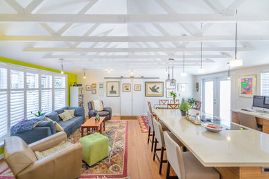 Foto di un ampio soggiorno contemporaneo aperto con libreria, pareti verdi e pavimento in legno massello medio