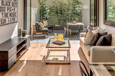 Idée de décoration pour une petite salle de séjour design avec un mur blanc, un sol en bois brun et un sol marron.