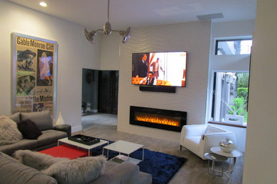 Exempel på ett mellanstort modernt allrum med öppen planlösning, med vita väggar, klinkergolv i porslin, en standard öppen spis, en spiselkrans i trä, en inbyggd mediavägg och grått golv