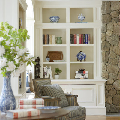 Mid-sized elegant enclosed medium tone wood floor and brown floor family room photo in Boston with white walls, a standard fireplace, a stone fireplace and a concealed tv