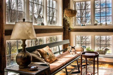 Imagen de sala de estar abierta rural de tamaño medio sin chimenea y televisor con paredes beige, suelo de madera en tonos medios y suelo marrón