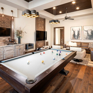 Ejemplo de sala de juegos en casa cerrada, de estilo americano, sin chimenea, con paredes beige, suelo de madera en tonos medios y televisor colgado en la pared
