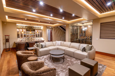 Imagen de sala de estar abierta contemporánea grande con paredes beige y suelo de madera clara