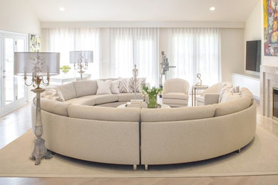 Ejemplo de sala de estar abierta ecléctica grande con paredes beige, suelo de madera clara, televisor colgado en la pared y suelo blanco